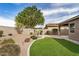 Charming backyard featuring artificial grass, desert landscaping, and a tranquil water fountain at 1008 W Heatherwood St, San Tan Valley, AZ 85140