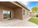 Covered patio with pavers, leading to artificial grass, desert landscaping, and a water fountain at 1008 W Heatherwood St, San Tan Valley, AZ 85140