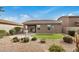 Beautiful backyard showing desert landscaping with a fountain, small grass area and patio at 1008 W Heatherwood St, San Tan Valley, AZ 85140