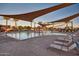 Large community pool area with lounge chairs, palm trees, and sun shades at 1008 W Heatherwood St, San Tan Valley, AZ 85140