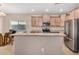 Open kitchen with stainless steel appliances, light wood cabinets, and granite countertops at 1008 W Heatherwood St, San Tan Valley, AZ 85140