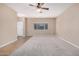 Spacious living room with plush carpet, neutral paint, and bright natural light from the large window at 1008 W Heatherwood St, San Tan Valley, AZ 85140