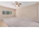 Spacious living room with plush carpet, neutral paint, and bright natural light from the large window at 1008 W Heatherwood St, San Tan Valley, AZ 85140