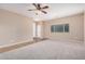 Spacious living room with plush carpet, neutral paint, and bright natural light from the large window at 1008 W Heatherwood St, San Tan Valley, AZ 85140