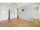 Bright bedroom with closet, ceiling fan, light walls, and a doorway to the attached bath at 10222 N 105Th Dr, Sun City, AZ 85351
