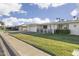 A street view of the home in a quiet neighborhood with well-kept lawns and sidewalks at 10222 N 105Th Dr, Sun City, AZ 85351