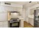Updated kitchen showcasing white cabinets, countertops, and stainless steel appliances at 10222 N 105Th Dr, Sun City, AZ 85351