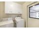 Functional laundry room with a washer, dryer, and overhead storage cabinets at 10222 N 105Th Dr, Sun City, AZ 85351
