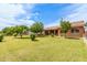 Expansive backyard featuring lush green lawn with large trees and a covered patio at 10535 W San Miguel Ave, Glendale, AZ 85307