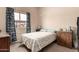 Bedroom with patterned bedspread, window, and blue curtains at 10535 W San Miguel Ave, Glendale, AZ 85307
