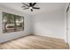 Bright bedroom featuring a ceiling fan and a large window with a view of the street at 10625 E Bramble Ave, Mesa, AZ 85208