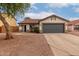 Charming single-story home with a well-maintained lawn, a gray two-car garage, and desert landscaping at 10625 E Bramble Ave, Mesa, AZ 85208