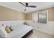 Bright bedroom with wood floors, ceiling fan, a bed, and a view to the outside at 11430 N 109Th St, Scottsdale, AZ 85259