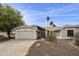 Well-maintained home exterior featuring desert landscaping, a two-car garage, and a welcoming front entrance at 11430 N 109Th St, Scottsdale, AZ 85259