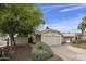 Well-maintained home exterior with a two-car garage, desert landscaping, and a neatly manicured lawn at 11430 N 109Th St, Scottsdale, AZ 85259