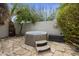 Private backyard hot tub retreat with stone pavers, decorative sun art, bench, and tranquil landscaping at 11430 N 109Th St, Scottsdale, AZ 85259
