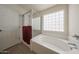 Bathroom featuring a glass-enclosed shower and a large soaking tub at 11563 W Jefferson St, Avondale, AZ 85323