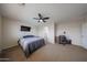 Spacious bedroom featuring a ceiling fan, TV, and dedicated workspace at 11563 W Jefferson St, Avondale, AZ 85323