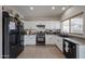 Close up of a kitchen with black appliances and white cabinets at 11563 W Jefferson St, Avondale, AZ 85323