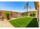 Lush backyard with artificial turf, decorative plants and a desert-themed rock garden at 11622 W Buck Mountain Ct, Surprise, AZ 85378