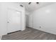Bedroom featuring wood-look flooring, a closet with sliding doors and access to another room at 11622 W Buck Mountain Ct, Surprise, AZ 85378