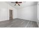Spacious bedroom featuring wood-look flooring, a ceiling fan, and plenty of natural light at 11622 W Buck Mountain Ct, Surprise, AZ 85378