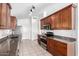 Well-lit kitchen featuring wood cabinets, granite counters, stainless steel appliances, and tile flooring at 11622 W Buck Mountain Ct, Surprise, AZ 85378