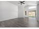 Spacious living room with light walls, vinyl plank flooring, and sliding glass door at 11622 W Buck Mountain Ct, Surprise, AZ 85378