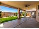 Covered patio with ceiling fan overlooking a manicured backyard with green artificial turf at 11622 W Buck Mountain Ct, Surprise, AZ 85378