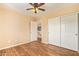 Bedroom features wood floors, ceiling fan, closet, and exterior views at 12325 W Canterbury Dr, El Mirage, AZ 85335