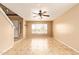 Living room features tile floors, neutral walls, ceiling fan and view of front yard at 12325 W Canterbury Dr, El Mirage, AZ 85335