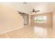 Living room features tile floors, neutral walls, ceiling fan and view of front door at 12325 W Canterbury Dr, El Mirage, AZ 85335