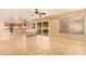 Open-concept living room featuring tile floors, ceiling fan, and sliding glass door leading to the backyard at 12325 W Canterbury Dr, El Mirage, AZ 85335