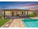 This backyard features a refreshing pool, covered patio with bar seating, and an outdoor kitchen at 12516 W Mclellan Ct, Glendale, AZ 85307