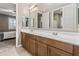 Bathroom featuring double sinks with a large mirror and wooden cabinets at 12516 W Mclellan Ct, Glendale, AZ 85307