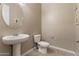 Powder bath featuring a pedestal sink, round mirror, tiled floor and toilet at 12516 W Mclellan Ct, Glendale, AZ 85307