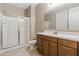 This bathroom features neutral walls and flooring, vanity with drawers, large mirror, and a glass-enclosed shower at 12516 W Mclellan Ct, Glendale, AZ 85307