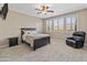 This bedroom features a ceiling fan, neutral walls, plush carpet, and natural light from the multiple windows at 12516 W Mclellan Ct, Glendale, AZ 85307