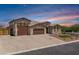 Charming single-Gathering home featuring a three-car garage, desert landscaping, and beautiful brick driveway at 12516 W Mclellan Ct, Glendale, AZ 85307