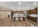 Open-concept kitchen with an oversized island, stainless steel appliances, and hardwood flooring at 12516 W Mclellan Ct, Glendale, AZ 85307