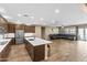 Open-concept kitchen and living room area with stainless appliances and a large leather couch at 12516 W Mclellan Ct, Glendale, AZ 85307