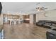 Open kitchen and living room area with ceiling fan and hardwood flooring at 12516 W Mclellan Ct, Glendale, AZ 85307