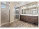 Well-lit bathroom with a glass shower and dual sinks set in a modern vanity at 12516 W Mclellan Ct, Glendale, AZ 85307