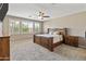 Spacious main bedroom with a ceiling fan, carpeted floor, and a wooden bed and cabinets at 12516 W Mclellan Ct, Glendale, AZ 85307