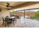 Covered outdoor kitchen and dining area with ceiling fan, a granite bar, and a view of the pool at 12516 W Mclellan Ct, Glendale, AZ 85307