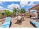 Backyard patio featuring lounge chairs, umbrellas, and built-in grill area at 13629 W San Miguel Ave, Litchfield Park, AZ 85340