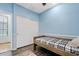 Charming blue bedroom features a single bed frame, and sliding closet doors at 13629 W San Miguel Ave, Litchfield Park, AZ 85340