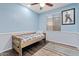 Bright bedroom features a wood bed frame, a ceiling fan and light blue walls at 13629 W San Miguel Ave, Litchfield Park, AZ 85340