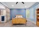 Bedroom featuring wood furniture, blue accent wall, and sliding closet doors at 13629 W San Miguel Ave, Litchfield Park, AZ 85340