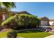 Attractive home featuring a lush green lawn, desert landscaping, and a partial driveway view at 13629 W San Miguel Ave, Litchfield Park, AZ 85340